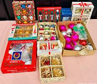 Overview of the full collection showing multiple boxes of vintage Christmas ornaments including boxed sets, loose baubles, wood nutcracker figurines, and natural fiber decorations.