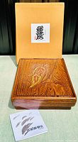 Original cardboard box with label, rosewood keepsake box with carved lid shown from front.