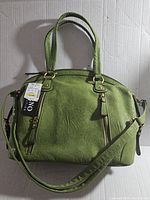 Front side view of olive green Bueno Collection handbag showing dual handles, zippered front pocket, long adjustable/removable strap, and attached tags indicating brand new condition.