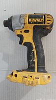 Side view of the yellow and black DeWalt impact driver body showing wear and no battery attached.