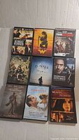 Top view of 9 DVDs in a 3x3 grid showing titles: Street Kings, Wonder Woman, Four Brothers, Sucker Punch, Gone Girl, Sherlock Holmes, Twilight Eclipse, The Notebook, Murder by Numbers