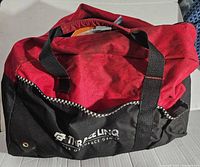 Closed red and black Tirtrace Linq branded tool bag with handles shown.