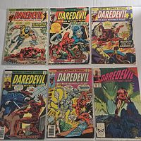 Photo showing six vintage Daredevil comic books with various covers, including Gladiator, Torpedo, Mandrill, and Death-Stalker characters.