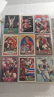 Photo showing nine vintage football cards in protective sleeves featuring Joe Montana, Steve Young, Jim McMahon and others.