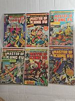 Photo showing seven Master of Kung Fu comic books with various martial arts action covers including games of death, chaos, and night ninja