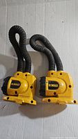 Pair of yellow Dewalt portable work lights with flexible necks shown side by side on a white background.