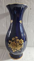Front view of the cobalt blue vintage vase displaying the gold floral design and gold rim