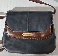 Front view of vintage Liz Claiborne purse showing flap with brown leather trim and gold-tone nameplate.