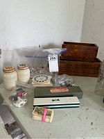 Photo showing all items on a table: mini teapots in a plastic bag, vintage salt and pepper shakers, View-Master slide reels, wooden boxes, and various small metal and ceramic items.