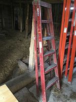 Full view of the red fiberglass 6 ft step ladder showing whole ladder structure with steps and side rails