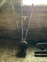 Front view showing tines, wheel, handle assembly