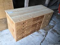 Front view of Ikea Ivar wooden drawer cabinet showing 15 drawers (12 small, 3 large) with natural wood grain finish and integrated pull handles.