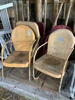 Two yellow chairs front row with three red chairs behind in barn setting