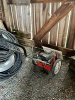 Side view of entire edger in barn showing frame, wheels, deck and handles