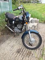 Front right three-quarter view of the entire motorcycle on concrete pad