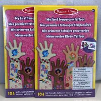 Photo of two sealed new packages of Melissa & Doug My First Temporary Tattoos, each package with 104 kid-friendly temporary tattoos.