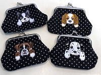 Four black polka dot change pouches with embroidered dog faces on front, each with a silver clasp closure.