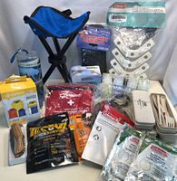 Overview of lot showing various camping outdoor gear and accessories arranged on white backdrop.