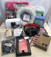 Photo showing various electronics including phone cases, cables, small fan, headphones.