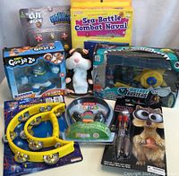 Photo showing the full assortment of new kids toys including games and light-up pen, some with visible packaging damage