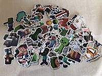 Photo showing a pile of colorful Minecraft-themed waterproof stickers featuring characters such as Steve, Creeper, Enderman, animals, and various items from the game.