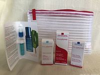 Clear view of all items together showing the mesh makeup bag and three boxed Clarins skincare samples.