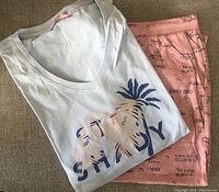 Folded pajama top and pink capris showing graphic and printed text pattern