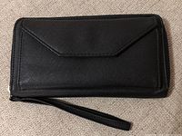 Closed view of new black clutch wallet with textured finish and wrist strap