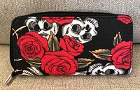 Front side of the wallet showing red roses and skulls graphic on black background.