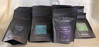 Seven resealable black bags of loose leaf tea from Pur & Simple, displayed front-side view showing different tea labels