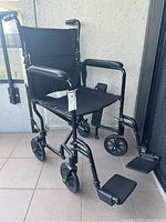 Front three-quarter view showing seat, armrests, small front casters and swing-away footrests