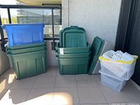 Overview of entire lot showing green and blue Rubbermaid bins, clear plastic bins and white mesh baskets