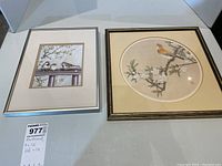 Photo showing two framed artworks on a table. Left is a signed original with three sparrows on a branch and right is Asian framed print with one bird on blossoming branch.