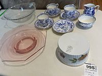 Overview of glass bowls, blue and white tea cups, saucers, cream and sugar bowls including Royal Worcester fireproof sugar bowl marked on underside, pink glass bowl, and clear glass bowl with beaded edge.