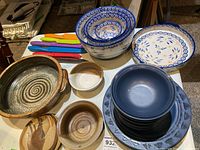 Top-down photo showing multiple ceramic dinnerware items including patterned bowls, plates, and side plates.