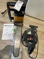 Photo of Husqvarna chainsaw with manual and electric Craftsman planer showing both items from above.