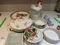 Full view of the items showing variety of serving dishes including covered bowls, a platter, and napkin rings
