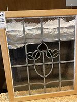 Full front view of the stained glass window with natural wood frame showing the floral stained glass design.