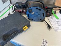 Mastercraft black plastic case for socket set with Craftsman palm sander, extension cord, and paint can in background