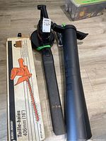 Two garden tools including a Black & Decker electric trimmer and Toro blower vac, along with original Black & Decker trimmer box.