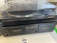 Side angle of Yamaha cassette deck and Sony turntable showing overall condition and dust cover on turntable.