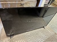 Front view of the Samsung 43 inch TV showing black screen and frame with metal stand legs