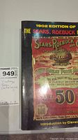View of the vintage Sears Roebuck catalog front cover with 1902 edition markings and colorful detailed print.