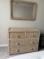 Wicker dresser with mirror in background, showing overall front profile with four drawers.