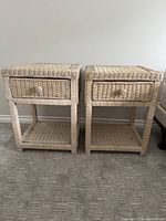 Photo showing two light-colored wicker nightstands side by side on carpet.