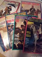 Photo showing seven Military History magazines, each with colorful covers depicting historic military figures and battles across various eras