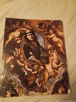 Cover of The Life of Brian Monty Python hardcover book showing artwork with cherubs and period costume figure