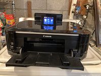 Front view of Canon colour inkjet printer showing the paper output tray and Canon logo.