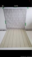 Backdrop displayed with damask pattern and wood floor design taped on a wall, showing overall design and structure.