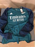 Front view of Adidas Real Madrid long sleeve soccer jersey showing logos and design details